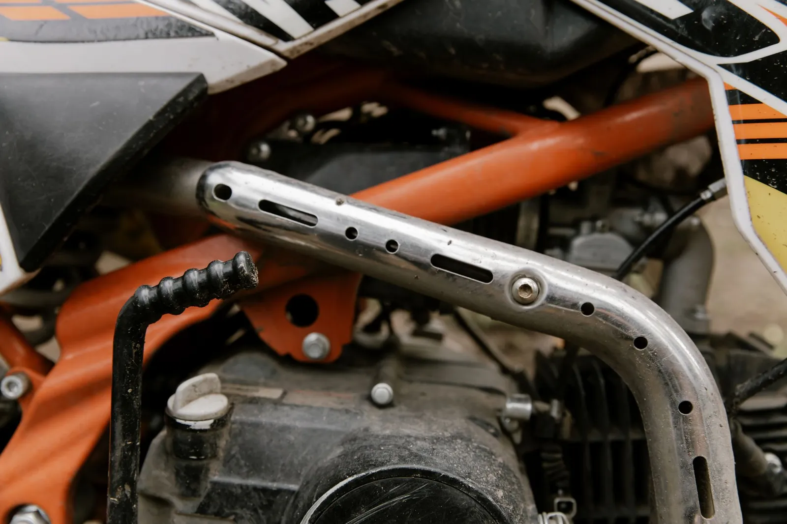 Close up of the exhaust pipe and engine of a dirt bike