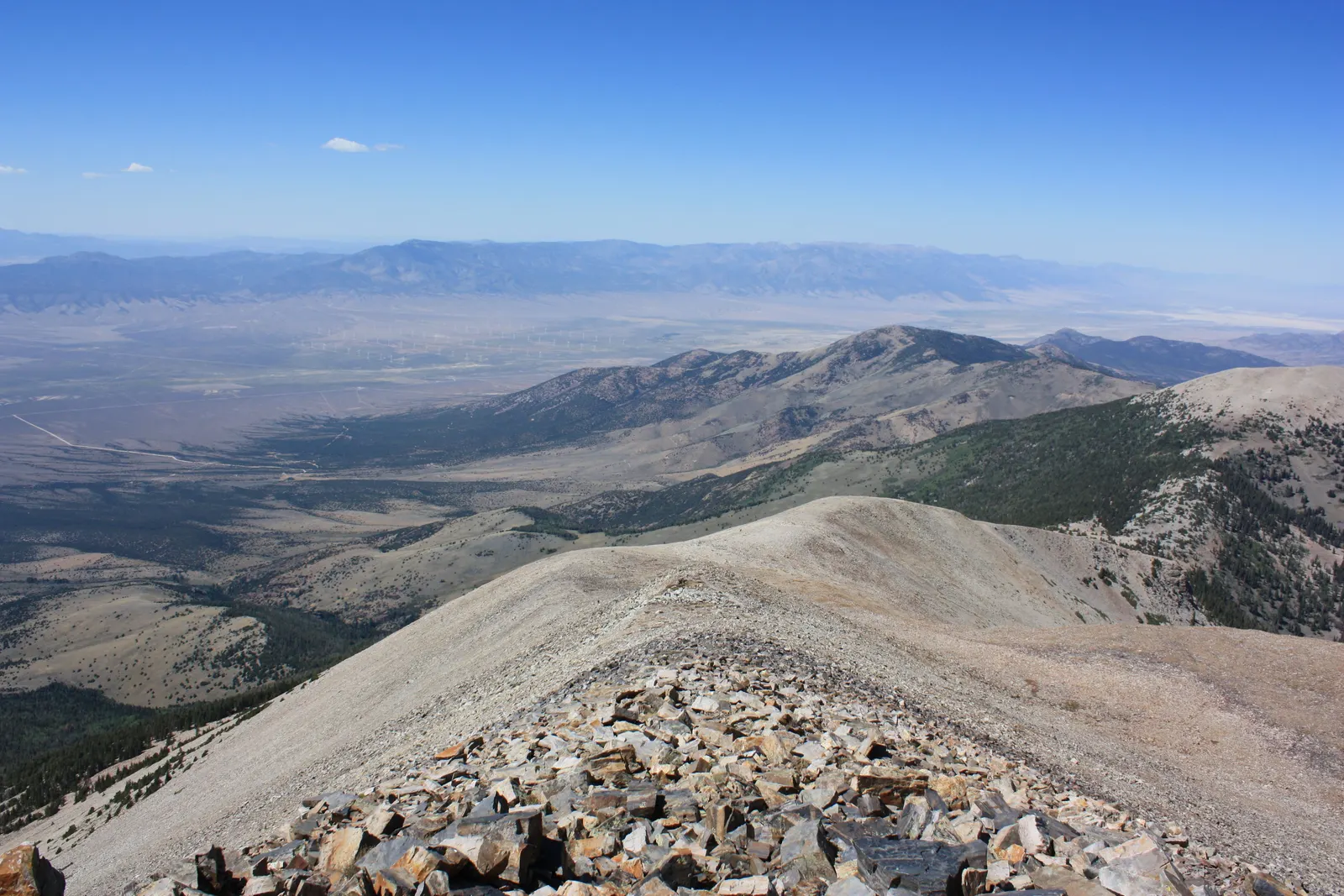 A rocky summit ridge looking down on desert valleys and distant mountain ranges from Wheeler Peak, Nevada