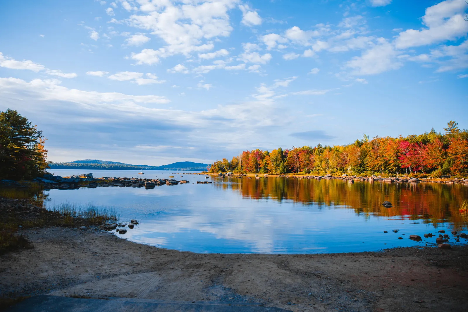 Autumn foliage reflected in still water at Steuben Lake in Maine