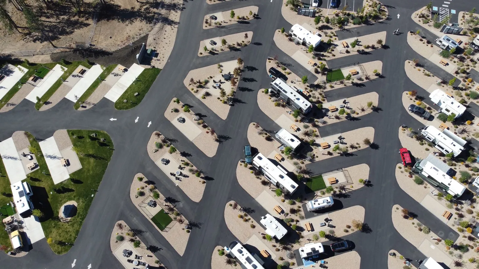 Aerial view of an RV park with rigs parked on paved pull-through sites
