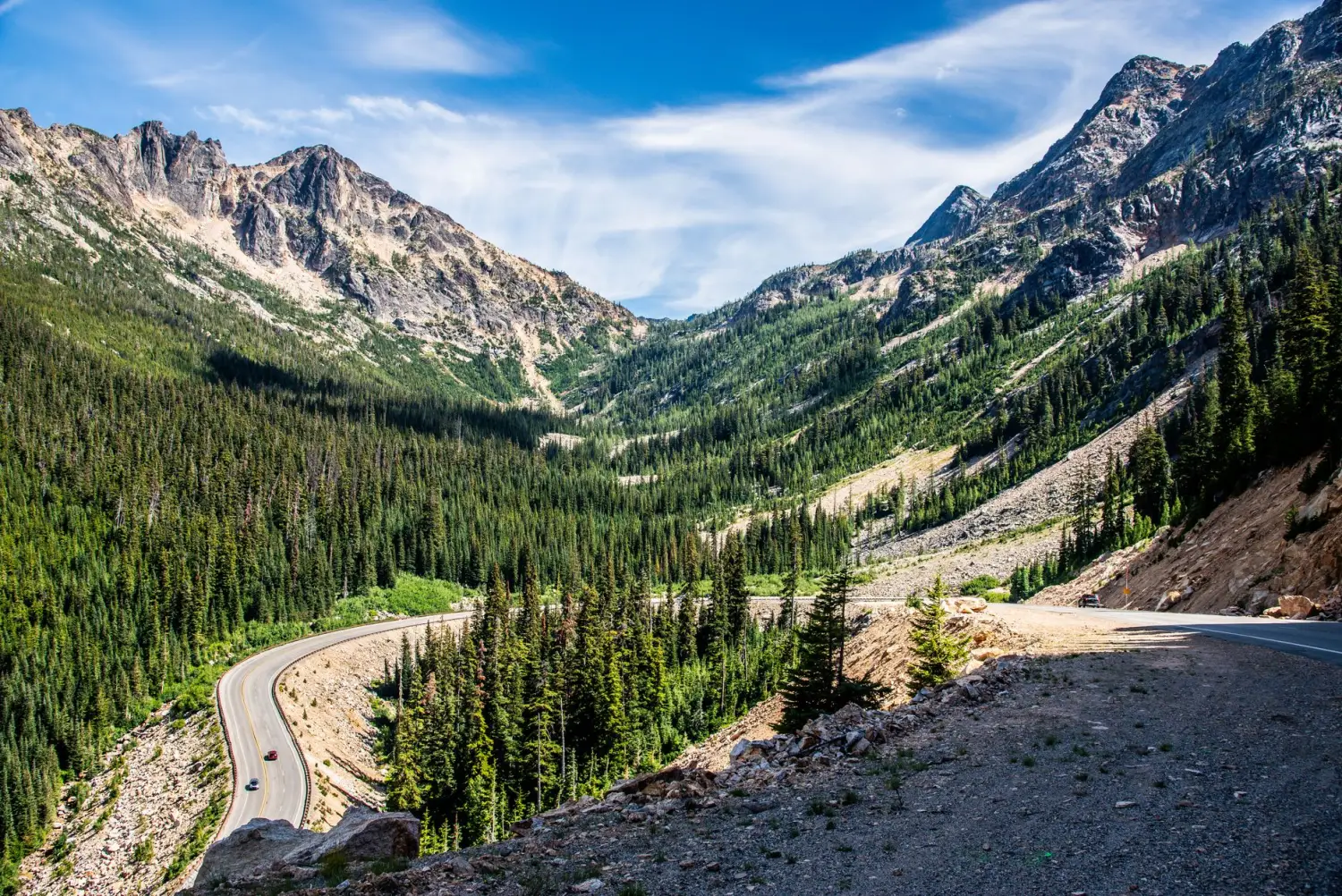 Two-lane highway winding through a forested valley in the Cascade Mountains, Washington